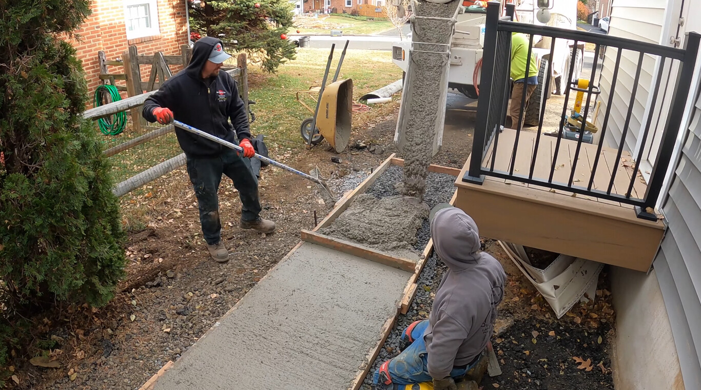 Crew installing concrete walkway in Holly Springs